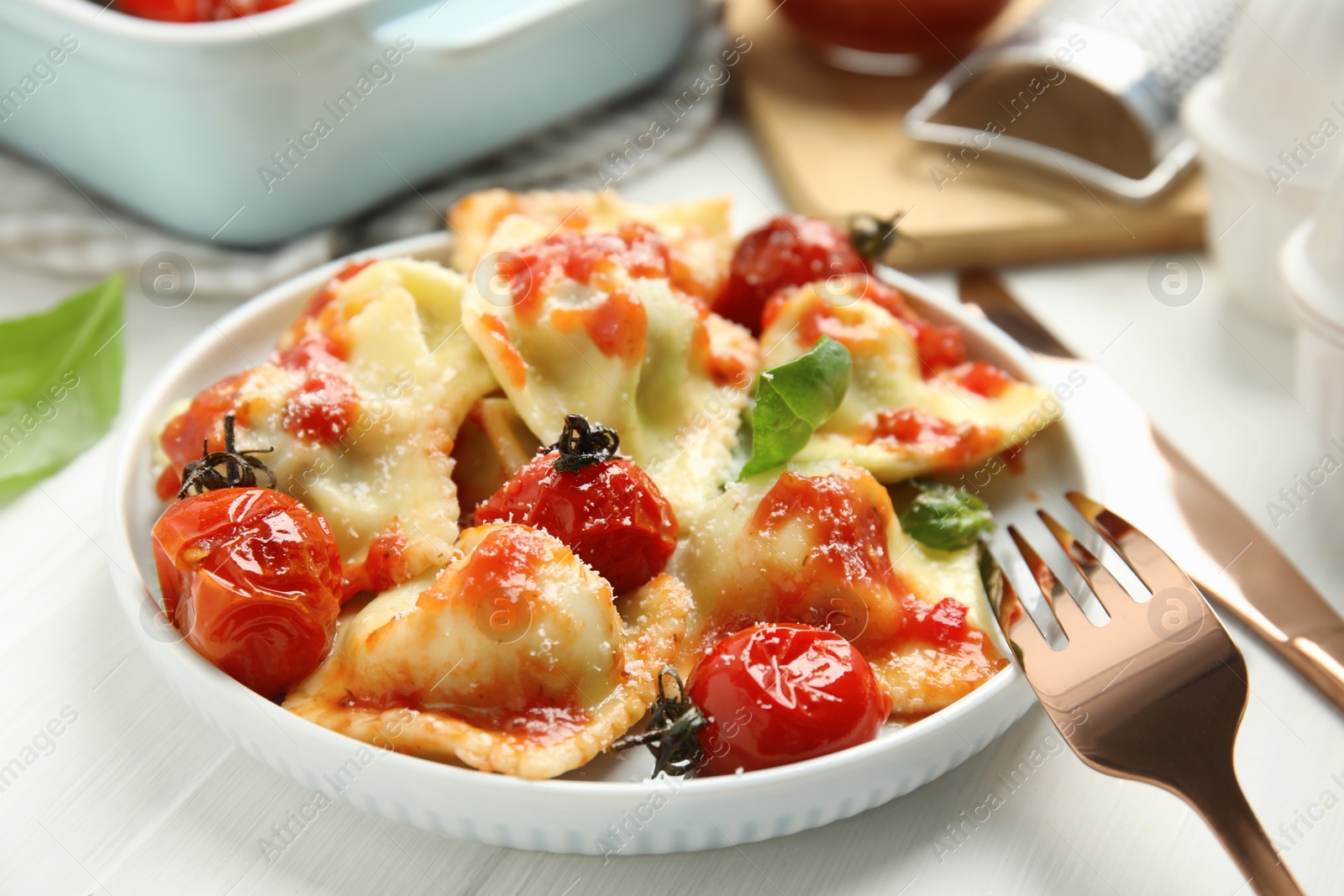 Photo of Tasty ravioli with tomato sauce served on white table