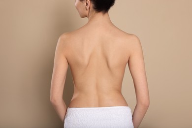 Photo of Back view of woman with perfect smooth skin on beige background, closeup