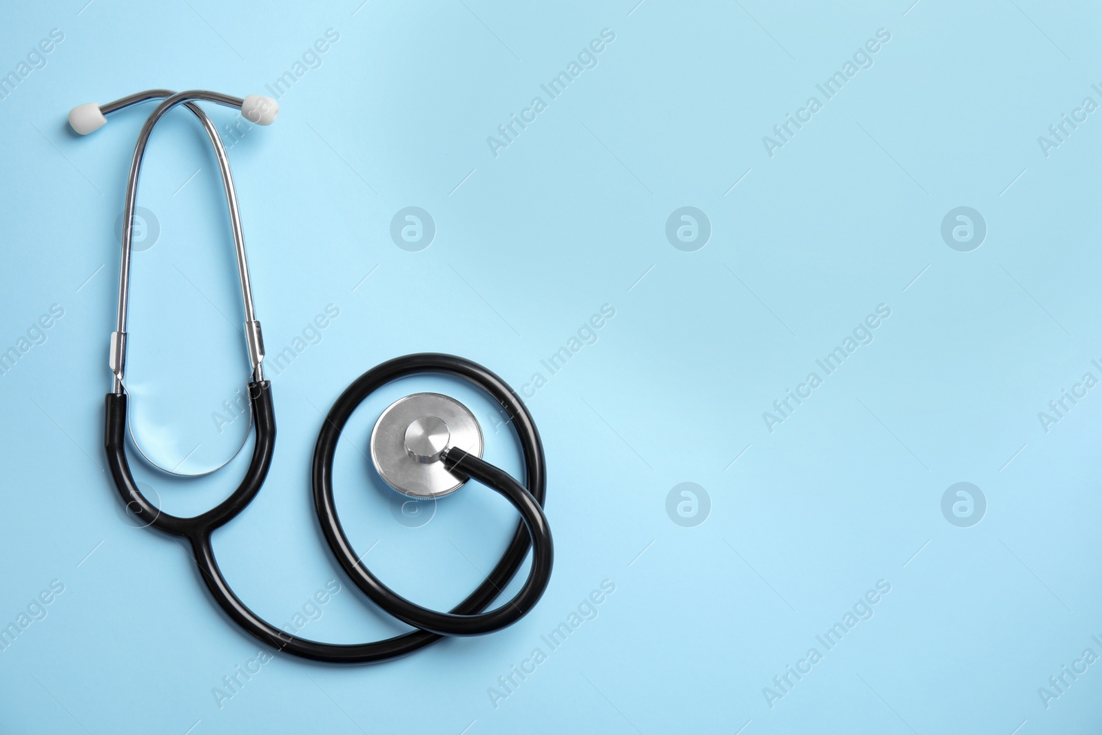 Photo of Stethoscope with space for text on color background, top view. Medical tool