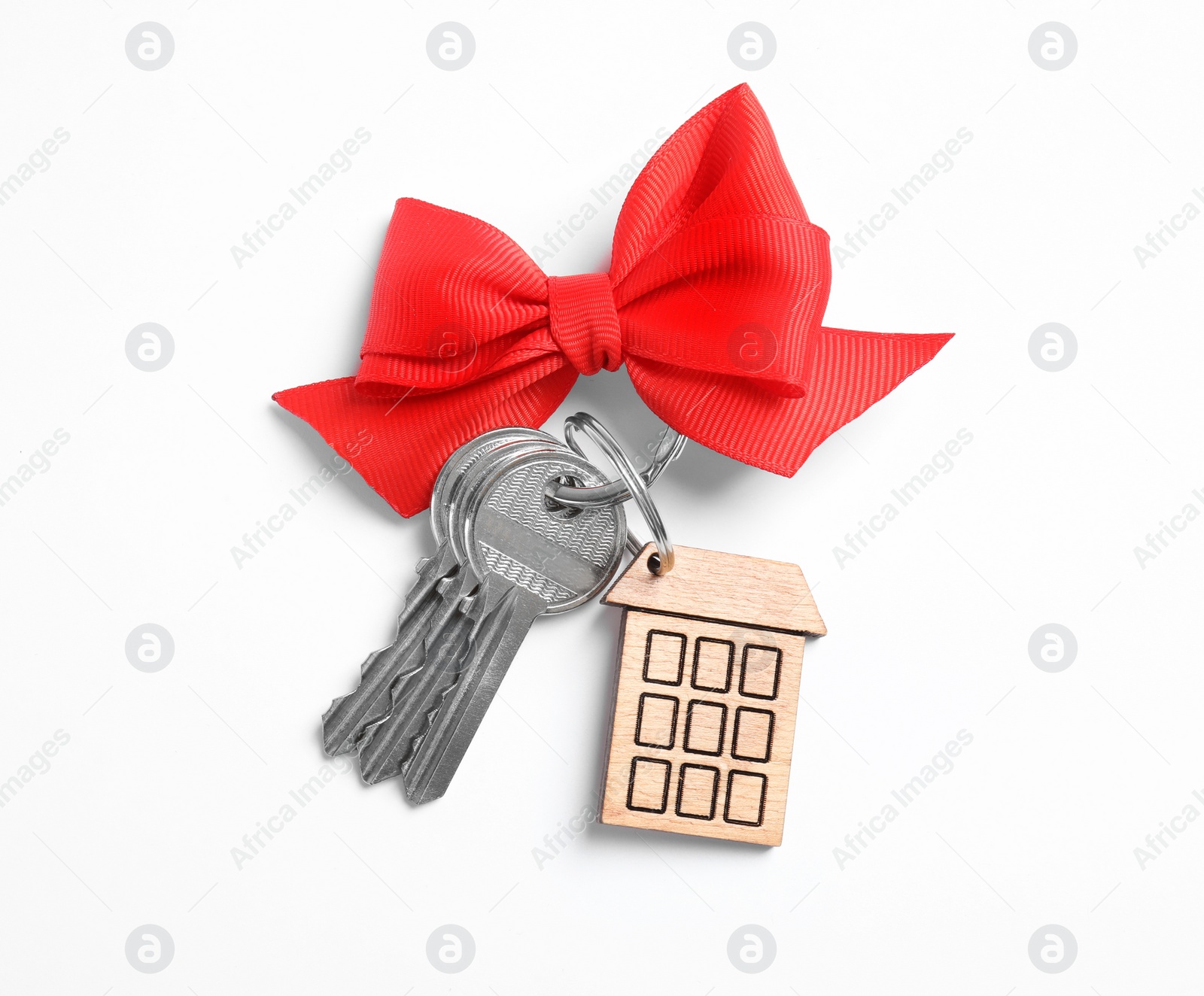 Photo of House keys with trinket and bow on white background, top view