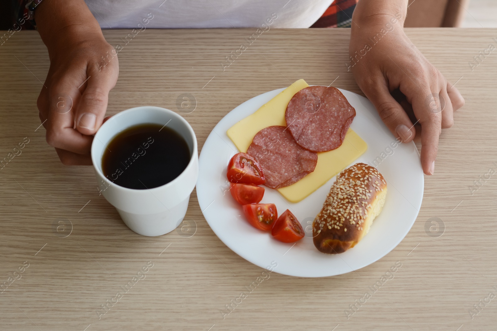 Photo of Woman having tasty nutritious breakfast at wooden table, closeup. Good morning