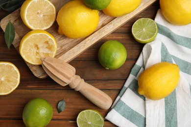 Photo of Squeezer with lemons on wooden table, flat lay