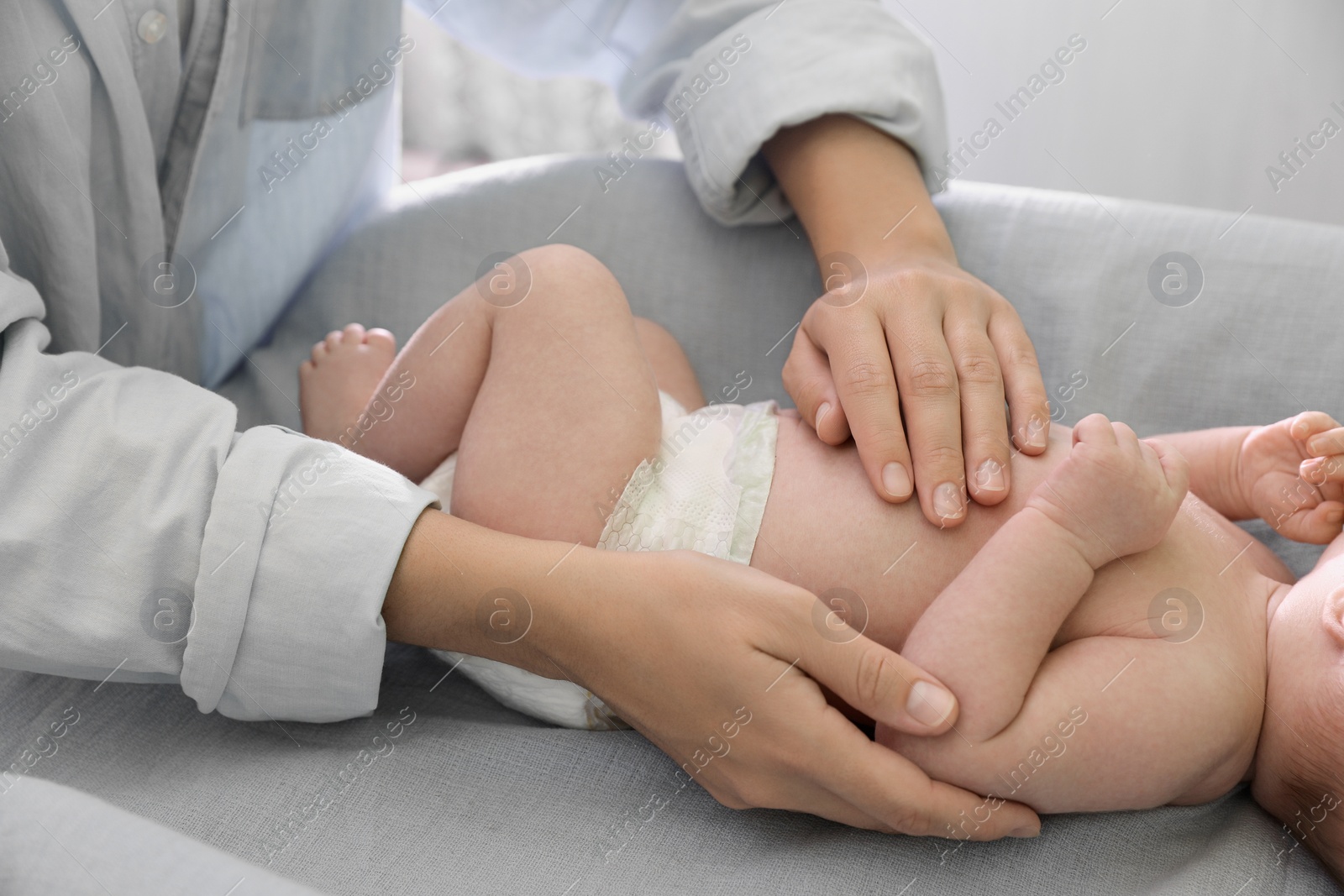 Photo of Mother taking care of her baby on changing table indoors, closeup