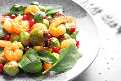 Photo of Plate of warm salad with Brussels sprouts on table, closeup