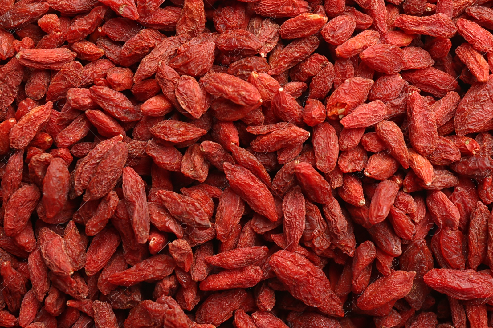 Photo of Many dried goji berries as background, closeup. Healthy superfood