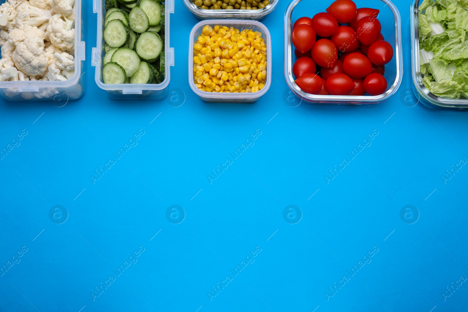 Photo of Plastic and glass containers with different fresh products on light blue background, flat lay. Space for text