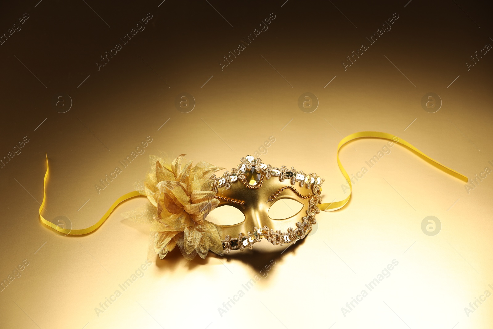 Photo of Beautifully decorated face mask on beige background. Theatrical performance