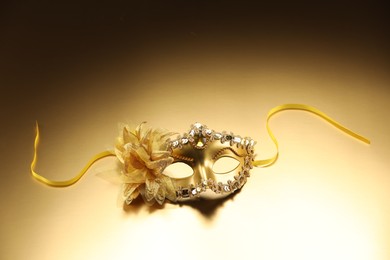 Photo of Beautifully decorated face mask on beige background. Theatrical performance