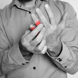 Image of Man suffering from rheumatism, closeup. Black and white effect with red accent in painful area