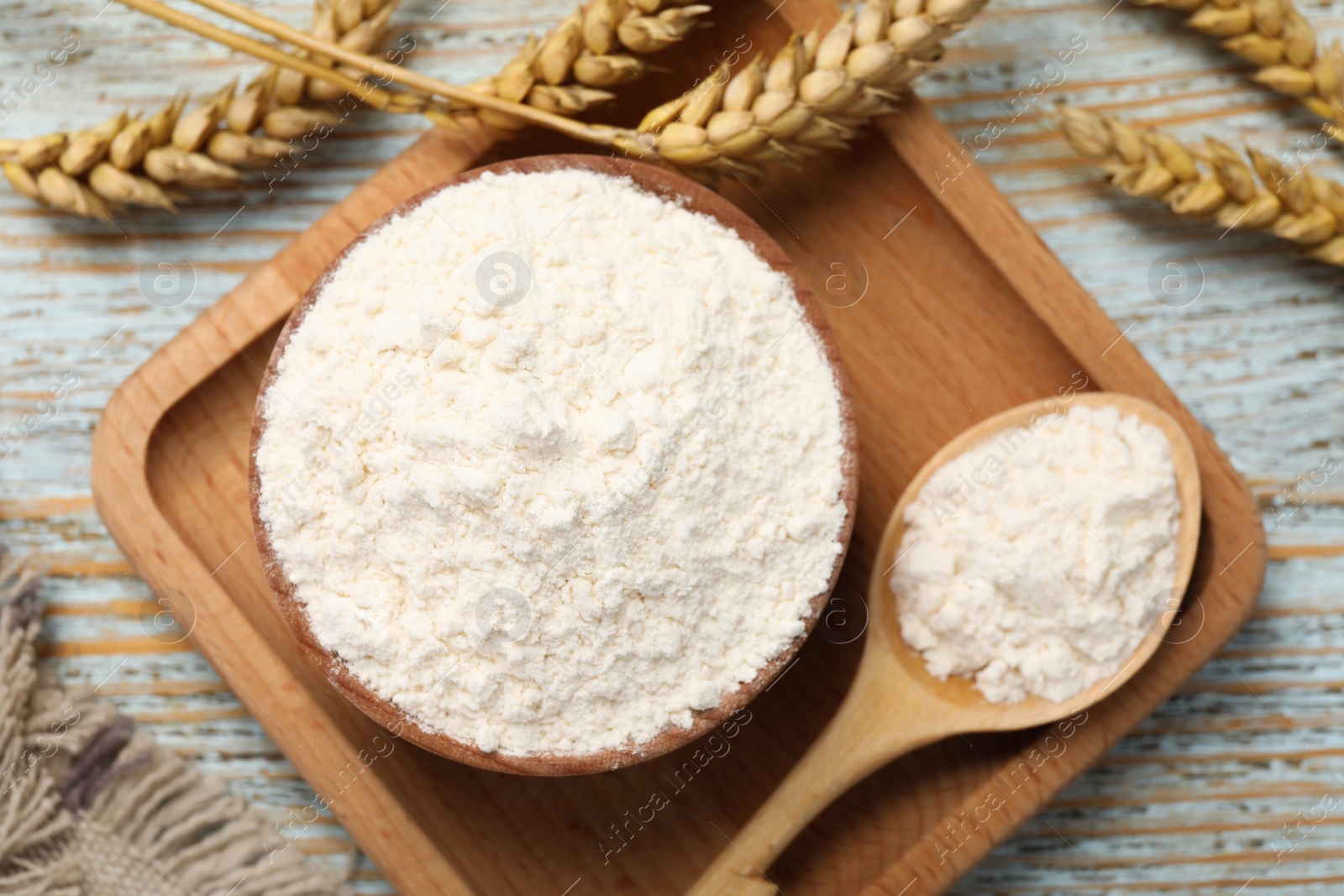 Photo of Organic wheat flour on light wooden table, flat lay