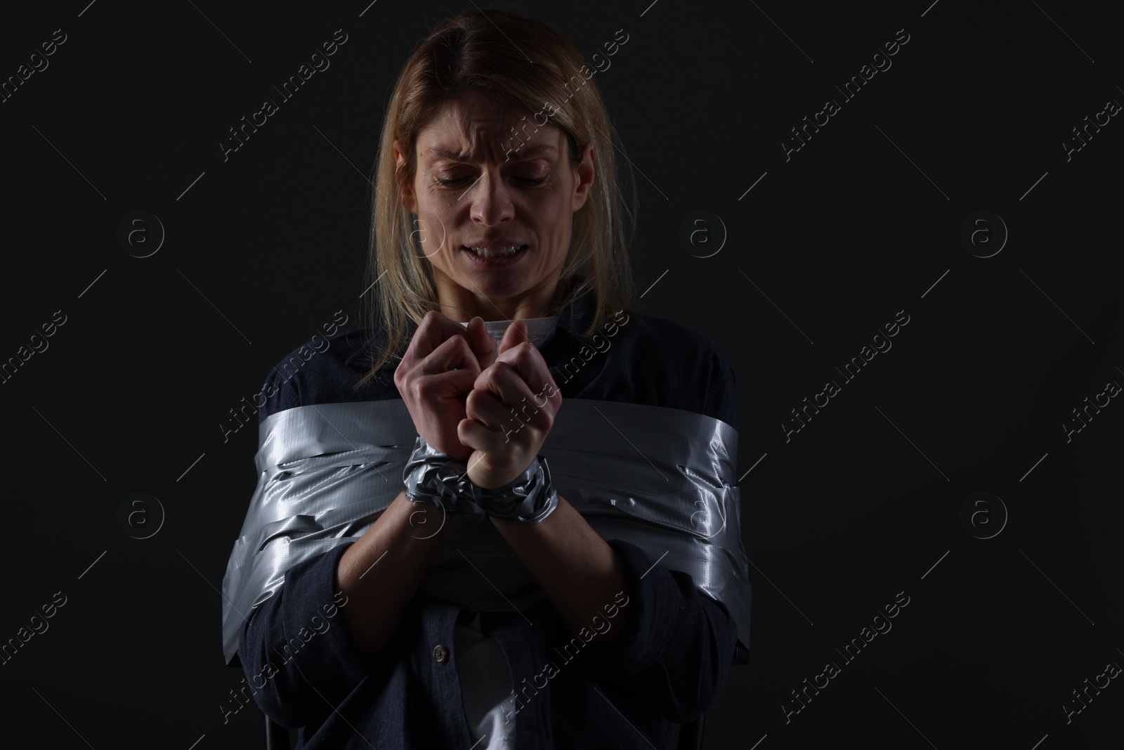 Photo of Woman taped up and taken hostage on dark background