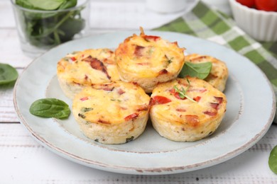 Photo of Delicious egg muffins with cheese and bacon on white wooden table, closeup