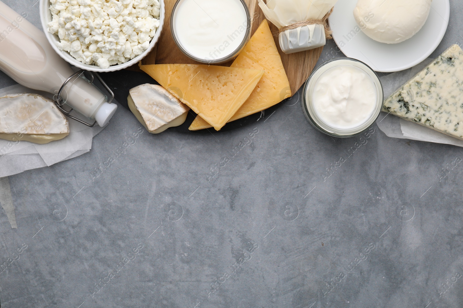 Photo of Different fresh dairy products on grey table, top view. Space for text