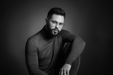 Portrait of handsome bearded man on dark background. Black and white effect