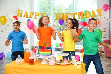 Photo of Happy children at birthday party in decorated room