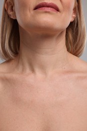 Woman with healthy skin on grey background, closeup