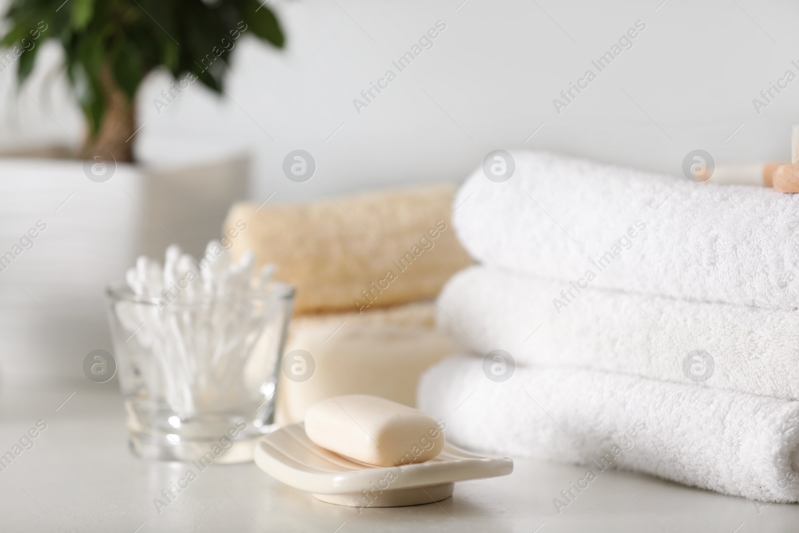 Photo of Soap bar and towels on white table indoors