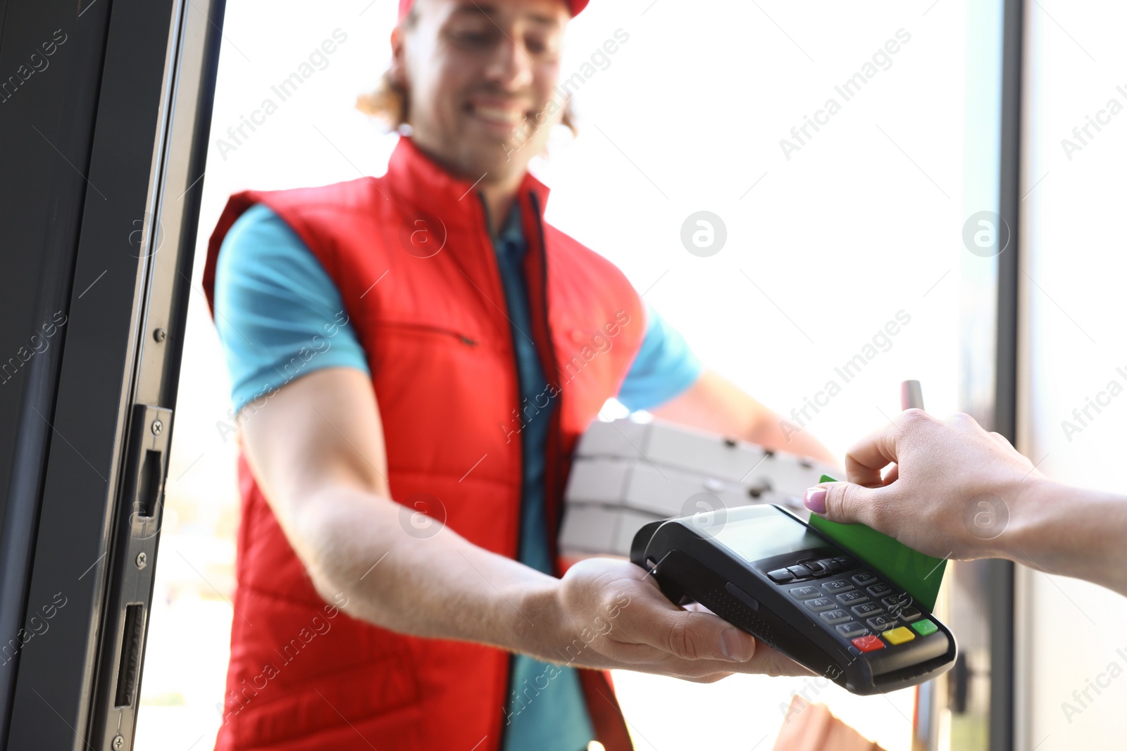 Photo of Woman paying for food delivery with credit card at door, closeup