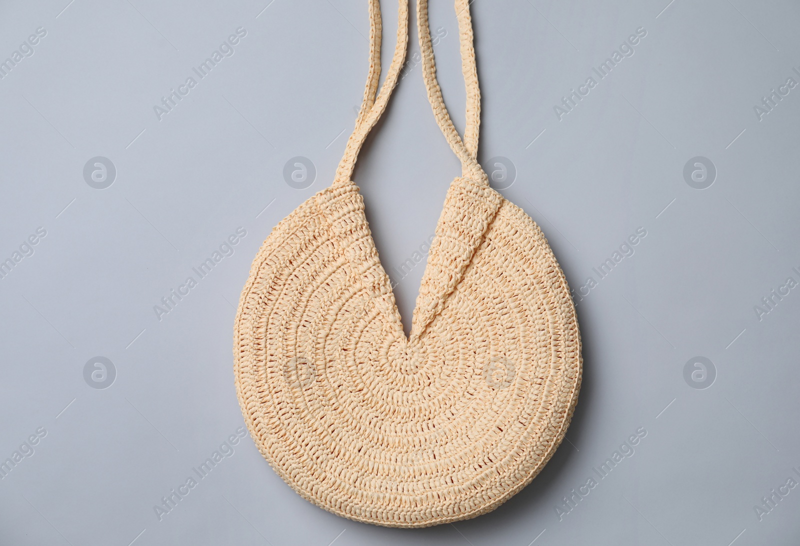 Photo of Stylish straw bag on grey background, top view. Summer accessory