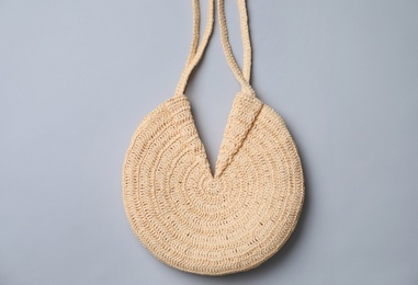 Stylish straw bag on grey background, top view. Summer accessory