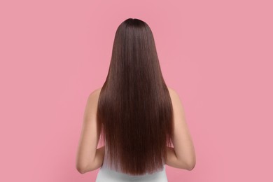 Photo of Woman with smooth healthy hair after treatment on pink background, back view