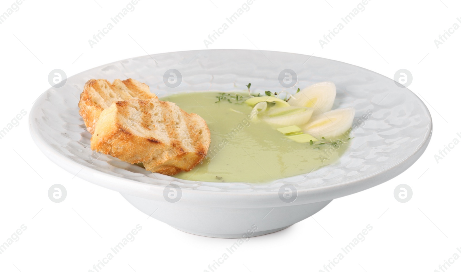 Photo of Plate of delicious leek soup with croutons isolated on white
