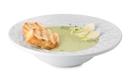 Photo of Plate of delicious leek soup with croutons isolated on white