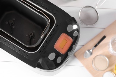 Breadmaker and different products on white wooden table, flat lay