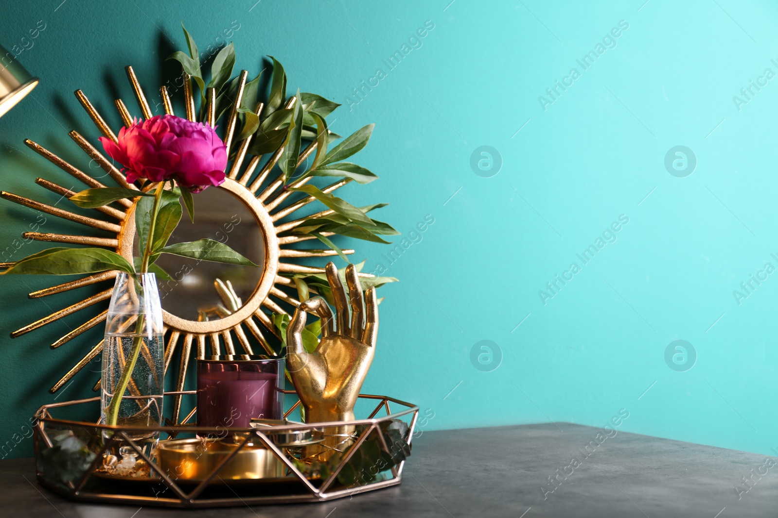 Photo of Composition with stylish accessories and interior elements on table near turquoise wall. Space for text