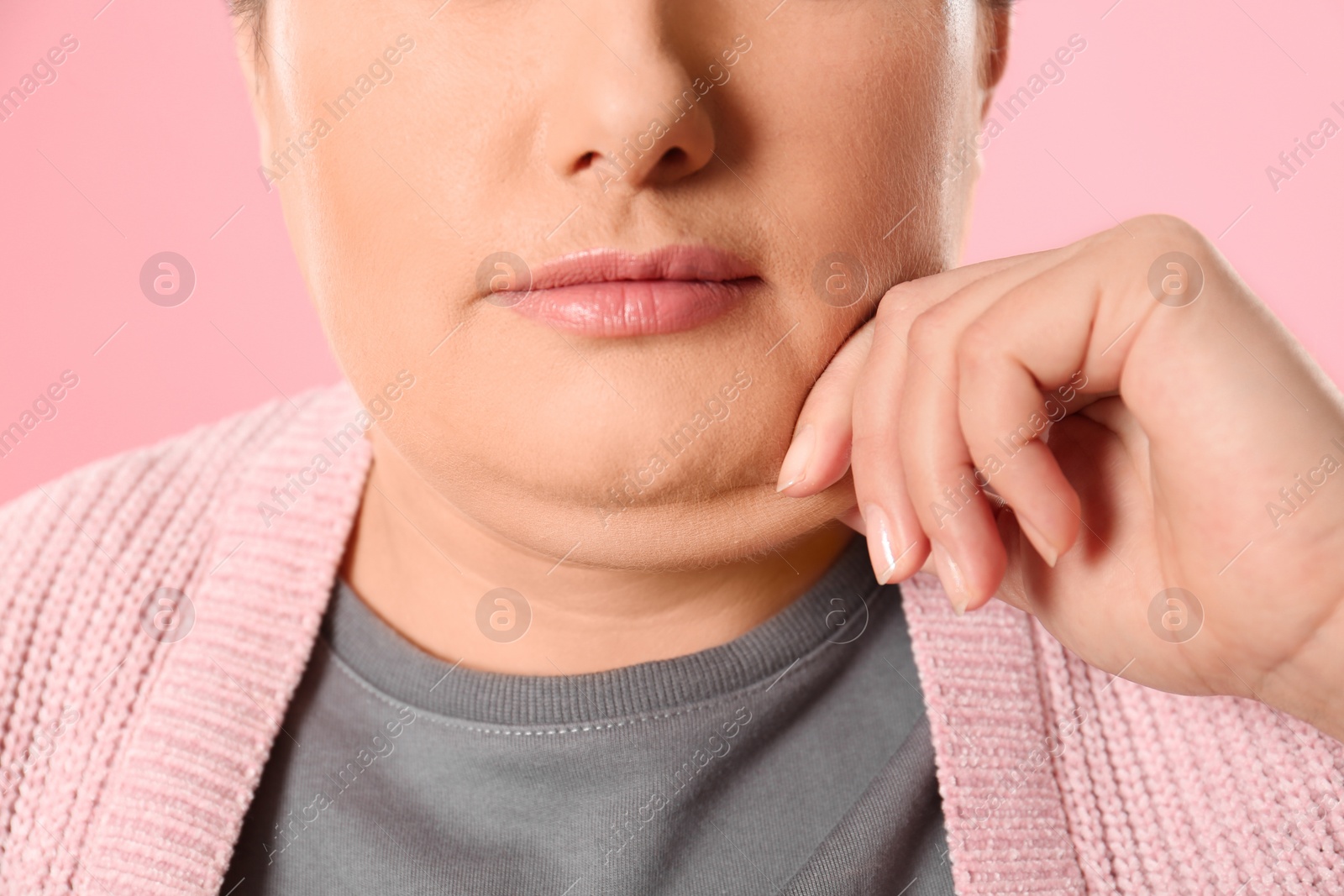 Photo of Woman with double chin on pink background, closeup