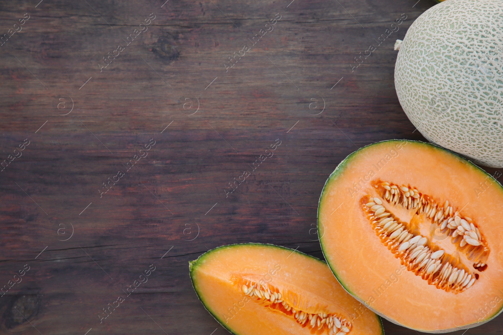 Photo of Tasty orange ripe melons on wooden table, flat lay. Space for text