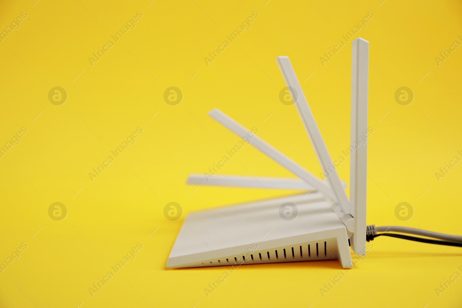 Photo of Modern Wi-Fi router on yellow background. Space for text