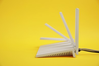 Modern Wi-Fi router on yellow background. Space for text