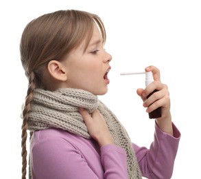 Little girl with scarf using throat spray on white background