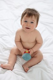 Photo of Cute baby boy with toy sitting on bed