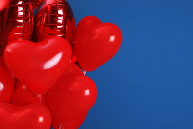 Photo of Bunch of heart shaped balloons for Valentine's day celebration on blue background, closeup. Space for text