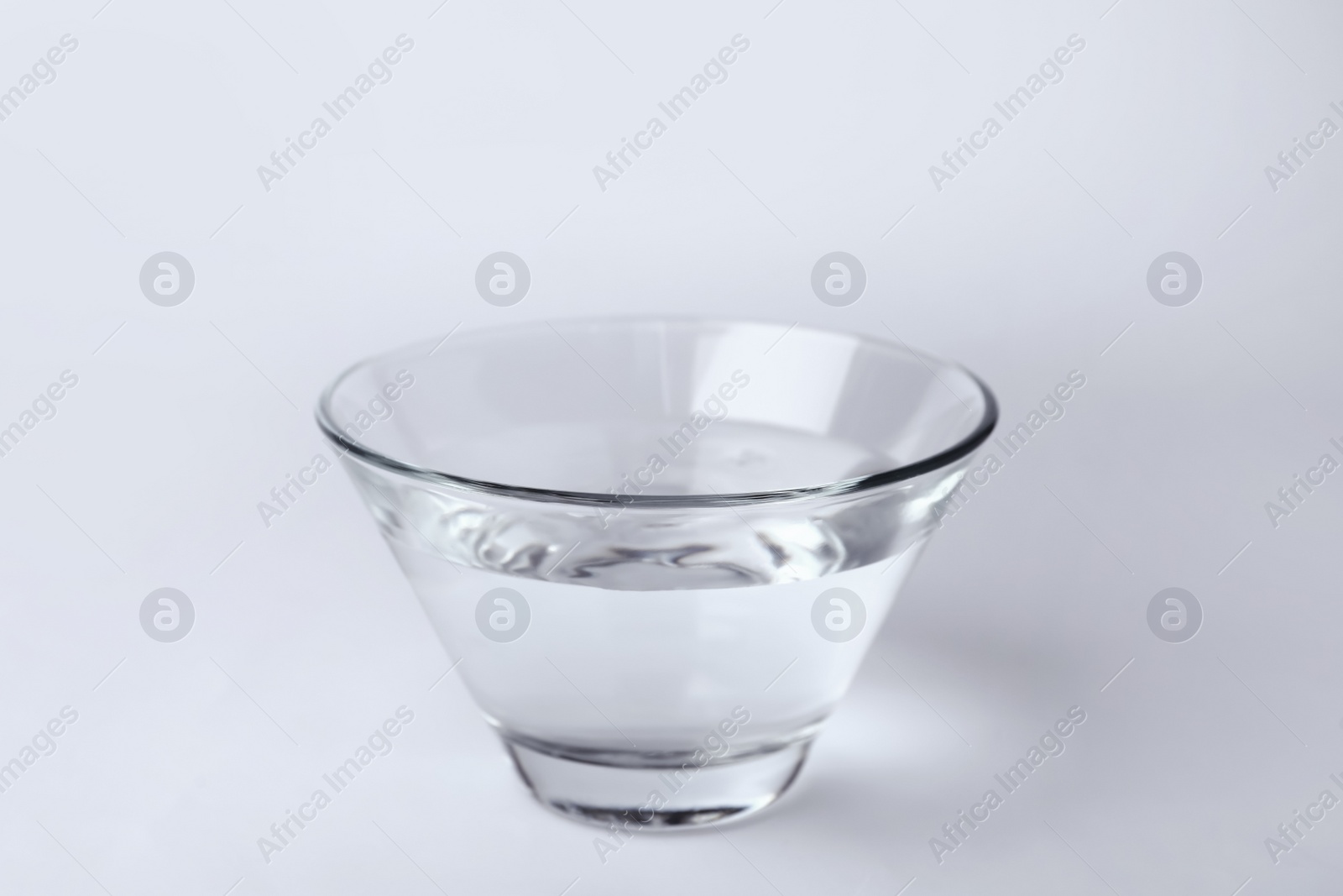 Photo of Glass bowl full of water on white background