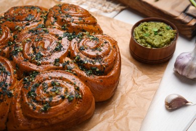 Traditional pampushka rolls with garlic and herbs on table, closeup