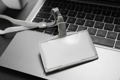 Photo of Blank badge and laptop on grey background, closeup