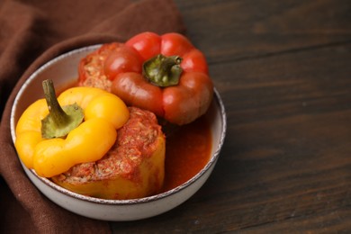 Photo of Delicious stuffed bell peppers on wooden table. Space for text