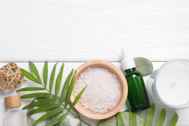 Flat lay composition with candle and different spa products on white wooden table. Space for text