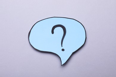 Photo of Paper speech bubble with question mark on light grey background, top view