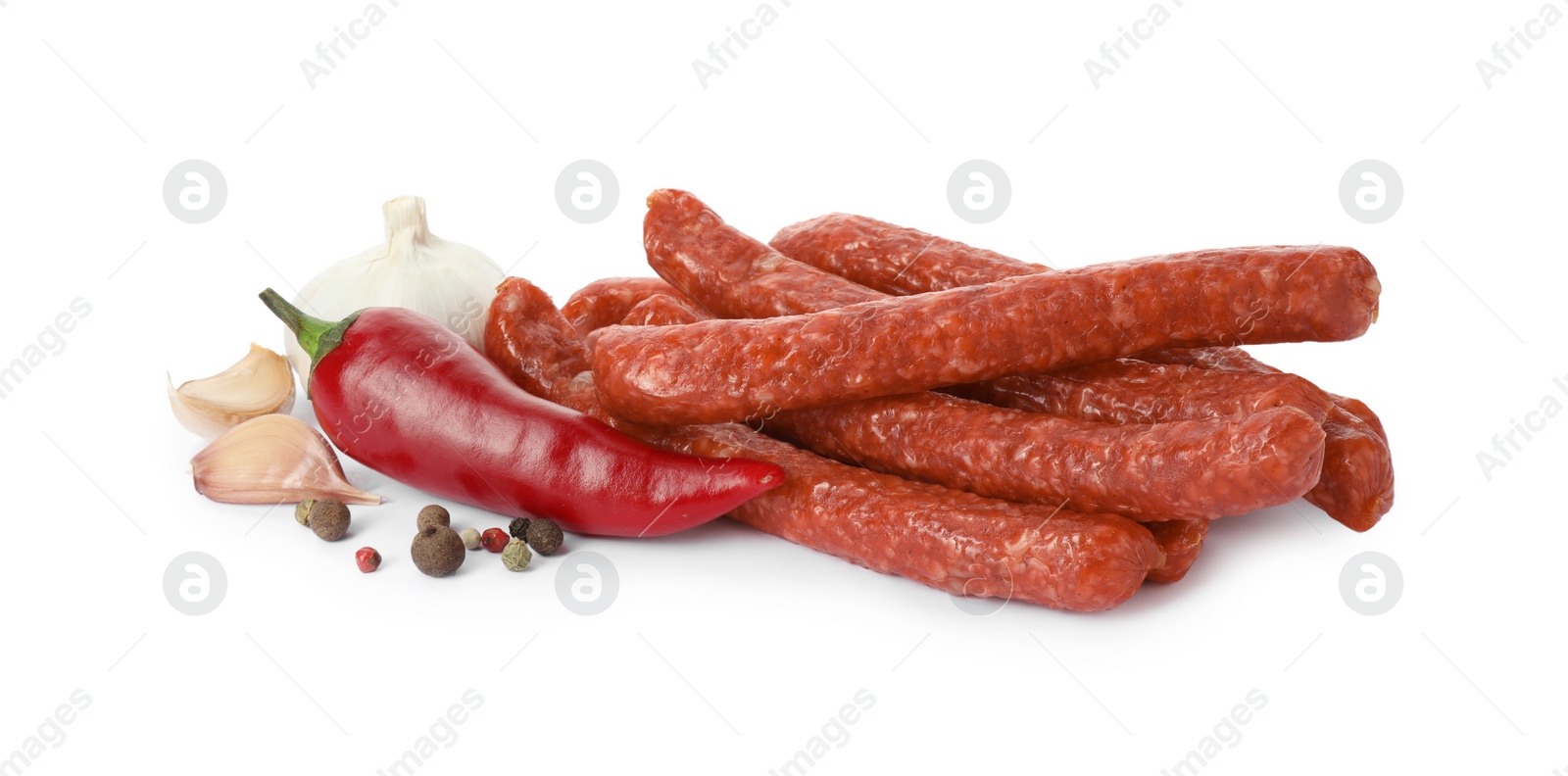 Photo of Many thin dry smoked sausages and spices isolated on white