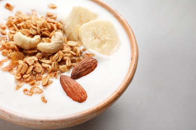 Bowl with yogurt, banana and granola on table, closeup