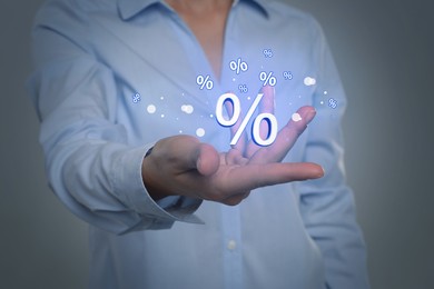Image of Woman showing virtual percent sign on light grey background, closeup. Discount concept
