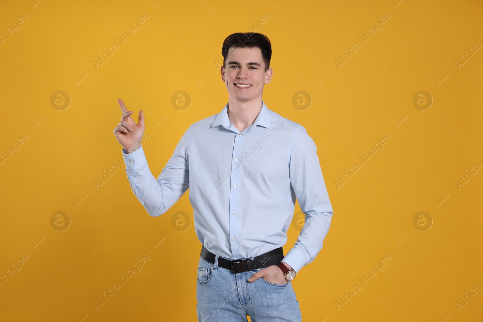 Photo of Portrait of handsome young man gesturing on yellow background