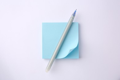 Photo of Blank paper note and pen on white background, top view
