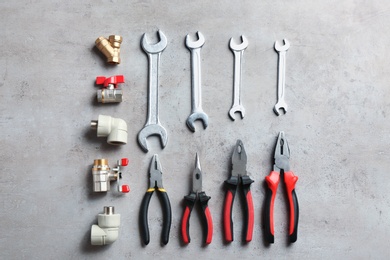 Flat lay composition with plumber's tools on grey background