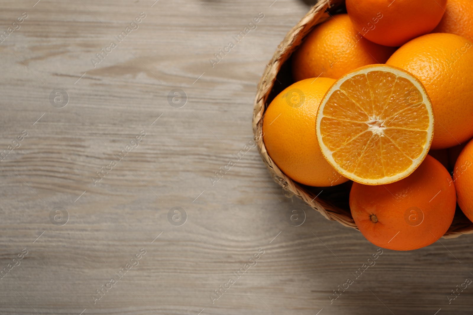 Photo of Many whole and cut oranges on wooden table, top view . Space for text