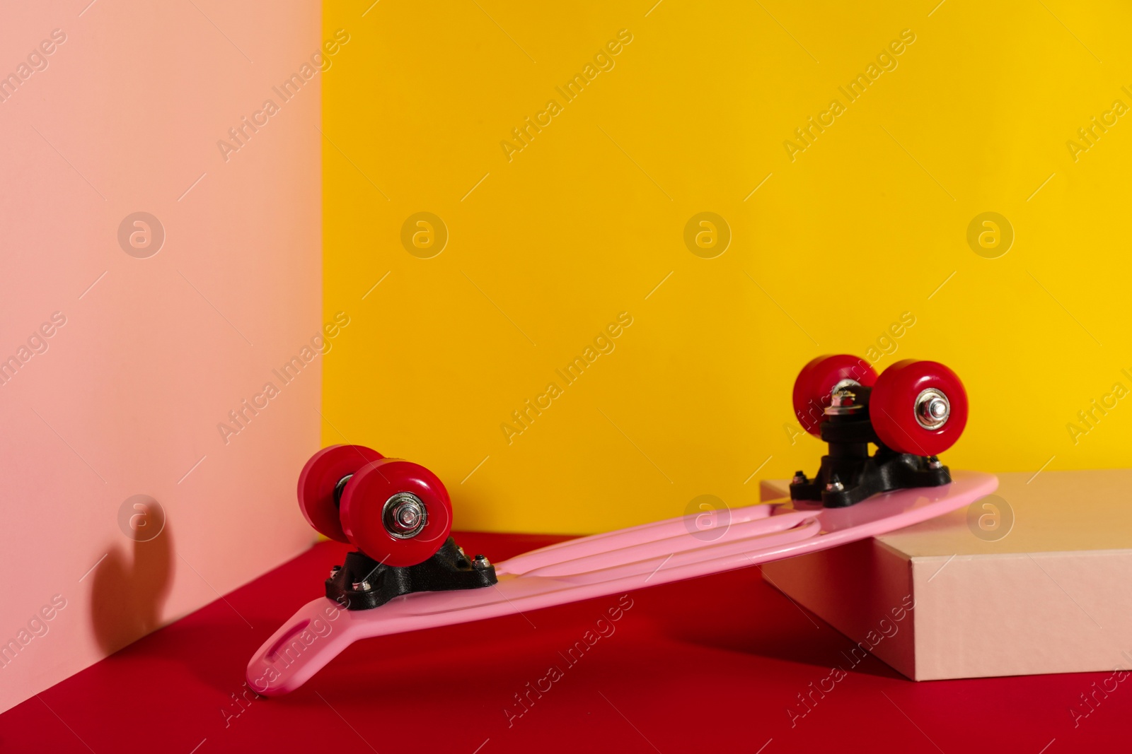 Photo of Pink skateboard on color background. Space for text